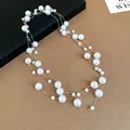 Detailed close-up of a long multi-layered pearl necklace with vintage French style - White