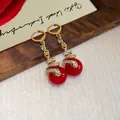 Elegant gold-tone snake earrings featuring a red pearl and pave crystal accents - Snake with Red Bead Style / Gold with Red