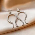 Elegant silver-toned snake-shaped earrings encrusted with sparkling cubic zirconia - Silver Snake Dangle / Silver