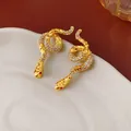 Elegant gold snake stud earrings featuring sparkling crystal pave and red stone eyes - Red Eye Hammered Snake Style / Gold with Red
