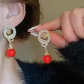 Elegant crystal-encrusted snake earrings featuring vibrant red pearl drop charms for women - Coiled Snake Red Bead Earring / Gold with Red
