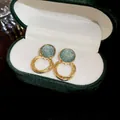 Close-up of golden layered hoop earrings with textured blue circular studs in a box - French Multilayer Ring Dangle Earrings (10#) / Gold-Blue