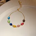 Gros plan d'un bracelet vintage en or avec sept zircons ovales colorés sur une assiette blanche. - Style Ovale Multicolore Ajustable (10#)
