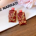 Close-up of New Chinese style red enamel earrings with gold floral branch details. - Gold / Red