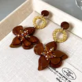 Detailed macro view of vintage brown floral dangle earrings with sparkling crystal centers - Silver Earring Post-Gold-Coffee