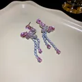 Close-up of elegant butterfly tassel earrings with sparkling pink cubic zirconia - Butterfly Tassel Style (HE15422) / Pink