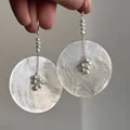 Dettaglio di orecchini boho in madreperla con delicati nappe di perle stile vintage. - Stile 3