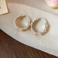 Detailed macro view of peach enamel hoop earrings with a textured beaded edge design - Huggie Earring (HE30850) / Light Orange