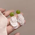 Macro view of French style drop earrings with green beads and white translucent discs. - Silver Needle Stud (4#)