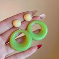 Detailed view of vibrant lime green acrylic hoop earrings held in hand for scale - Silver Post Stud Earrings (7#)