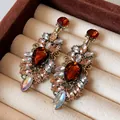 Gros plan de boucles d'oreilles vintage style palais avec cristaux ambre - Coloré