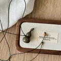 Vista dettagliata di una collana vintage con ciondolo a forma di zucca in legno su vassoio - Stile 69 (69#)