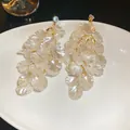 Eleganti orecchini a nappa in conchiglia con petali iridescenti e dettagli dorati. - Stile 58