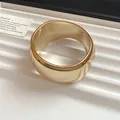 Close-up of a chunky geometric gold bangle with a high-polished metallic finish - Irregular / Gold