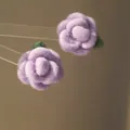 Vista macro dettagliata che mostra la morbida trama floccata di questi orecchini a rosa - Viola