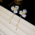 Detailed view of elegant white acrylic flower earrings with hanging golden chain tassels - 44# Gold White Floral Tassel