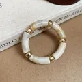 Close-up detail of a vintage marbled acrylic bracelet featuring polished golden spacers - Bamboo Segment Gold Bead Bracelet / Off White