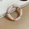 Macro detail shot of a pink marbled acrylic segment bracelet with elegant gold beads - Pink Smudge Acrylic Segment Bracelet / Light Pink