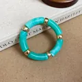 Detail view of teal marbled acrylic bracelet with gold-tone spacers resting on a vintage book - Turquoise Smudge Segment Bracelet / Green
