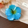Close-up detail of the large blue pleated flower hair claw clip with striped texture design - Blue