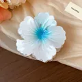 Close-up of white flower hair claw clip with blue gradient center and pleated texture - Blue-White