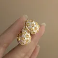 Elegant vintage C-shaped white enamel hoop earrings with gold floral rhinestone accents. - C-Shaped Ear Cuff / Gold-White