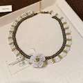 Macro detail of handmade glass beaded lace necklace with white camellia flower focal. - 7# Necklace / Gold-White-Black