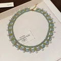 Primo piano di una collana in pizzo con perline di vetro blu e gocce di perle bianche. - Stile 6 Collana / Grande / Oro blu bianco