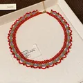 Dettaglio di collana di perle rosse e oro con elegante motivo etnico a festoni. - Collana Stile 2 / Oro-Rosso-Grigio