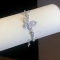 Detailed macro shot of a silver butterfly bracelet with shimmering zircon stones on display. - Silver