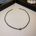 Close-up detail of a faceted black crystal necklace featuring a cute shell cat head pendant - Necklace / Black