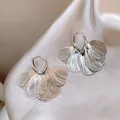 Eleganti orecchini a cerchio in argento con petali testurizzati su sfondo di raso. - Stile Cerchio in Petalo di Metallo (57#) / Argento