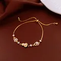 Elegante pulsera bañada en oro con dijes de herradura de circonita y perlas delicadas - Dorado-Negro (Bañado en Oro 18K)