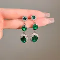 Detail view of vintage emerald green oval dangle earrings with rhinestone accents - Oval Fringe Style / Silver Needle - Emerald Green