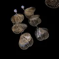 Close-up of elegant floral tassel earrings with sparkling rhinestones and filigree petals - Petal Tassel Style / Silver
