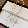 Vista dettagliata di una elegante collana di perle a più strati in un portagioie color beige - Stile Retro Francese / Argento