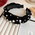 Close-up detail of a black braided velvet headband adorned with elegant pearls and silver beads. - Black Velvet Pearl Embellished Style