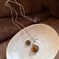 Close-up of tiger's eye planet pendant necklace on a decorative ceramic dish - Tiger Eye Saturn Unicorn Style (31#) / Silver