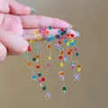 Close-up view of colorful crystal beaded tassel earrings featuring a vibrant dopamine style - Style 47 Navy Daisy