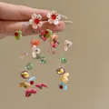 Detailed macro shot of colorful dopamine floral tassel earrings featuring crystal beads. - Style 44 Black Bird Print