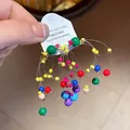 Close-up of vibrant dopamine style colorful beaded tassel earrings on a card - Size 8
