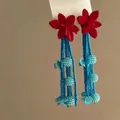 Close-up of vibrant red flower earrings with long blue beaded tassels and sphere accents. - 24#