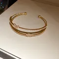 Elegante bracciale rigido a doppio strato con farfalle dorate e zirconi brillanti - Oro