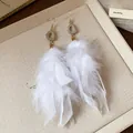 Detailed shot of white feather tassel earrings with elegant druzy stone accents - Feather Tassel Style (HE23665) / Gold-White