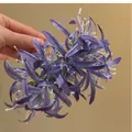Detailansicht einer lila Stoff-Spinnenlilie Haarklammer für Damen in eleganter Handhaltung - 48# Haarkralle - Violette Spinnenlilie