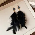 Detailed view of elegant long black feather tassel earrings with blue stone detail. - Feather Tassel Style (HE23665) / Gold-Black