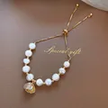 Elegant adjustable white pearl bracelet with gold shell pendant on textured leather - Freshwater Pearl Shell Bracelet