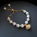 Elegant adjustable cat's eye stone beaded bracelet with a gold sparkling shell charm - Gold-Plated Cat's Eye