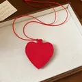Close-up of a red leather heart-shaped sunglasses storage pouch pendant necklace - Necklace / Red