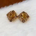 Ohrstecker im Vintage-Palaststil mit bernsteinfarbenem Zirkonia auf weißem Fellhintergrund - Gold